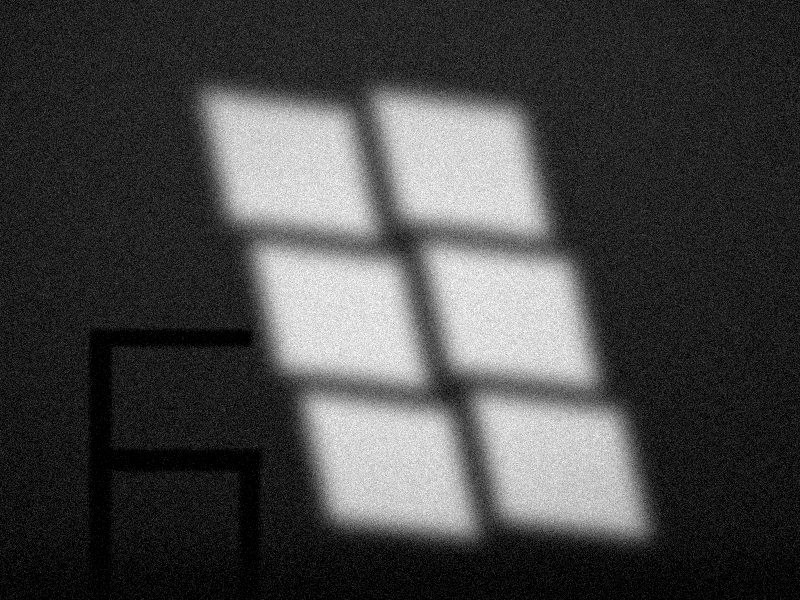 Lumière d'une fenêtre projetée sur un mur à côté d'une chaise, noir et blanc